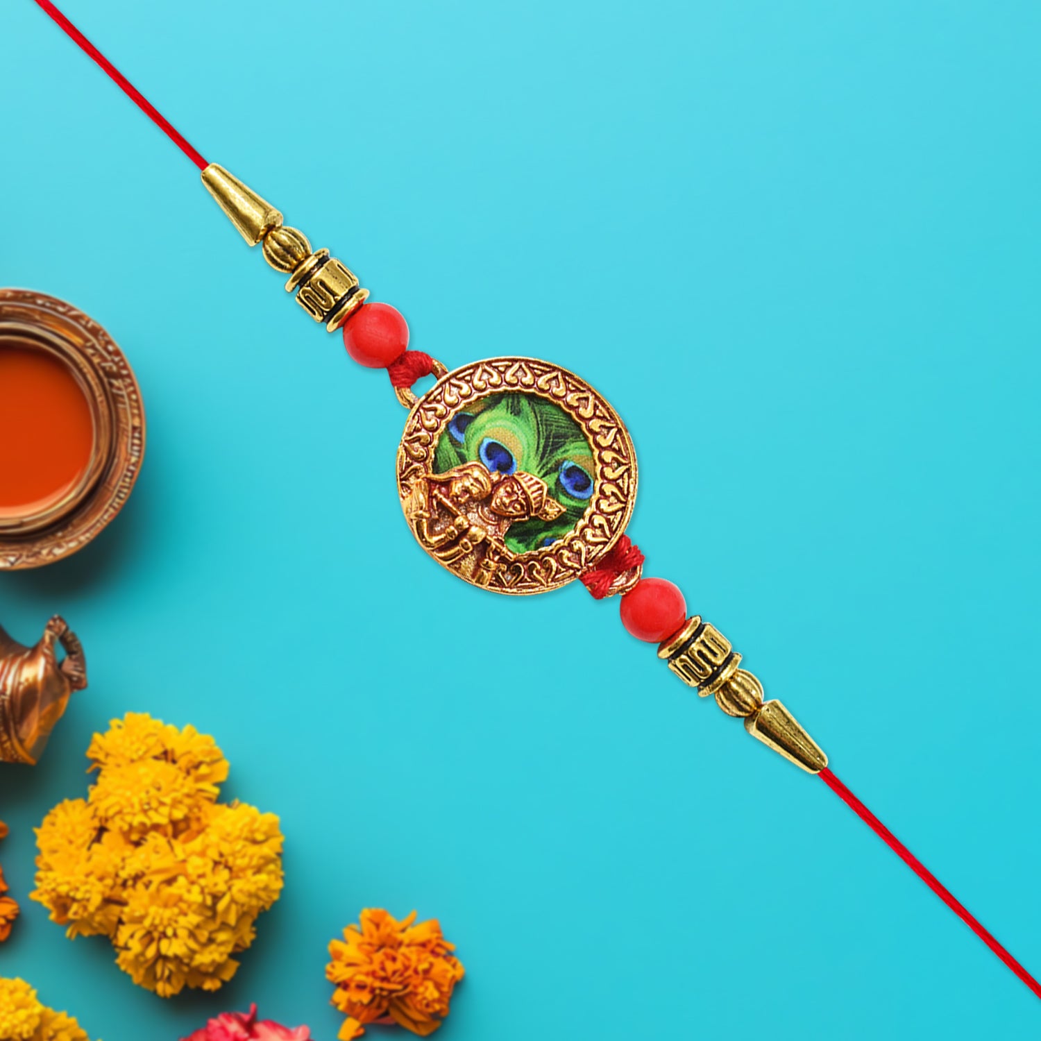 Traditional Krishna Rakhi With Peacock Feather Design And Decorative Beads On Red Thread Traditional Krishna Rakhi With Peacock Feather Design And Decorative Beads On Red Thread